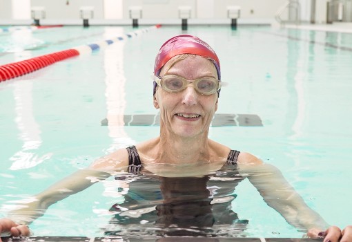 Better member in the swimming pool wearing goggles and a swim hat Better member in the swimming pool wearing goggles and a swim hat